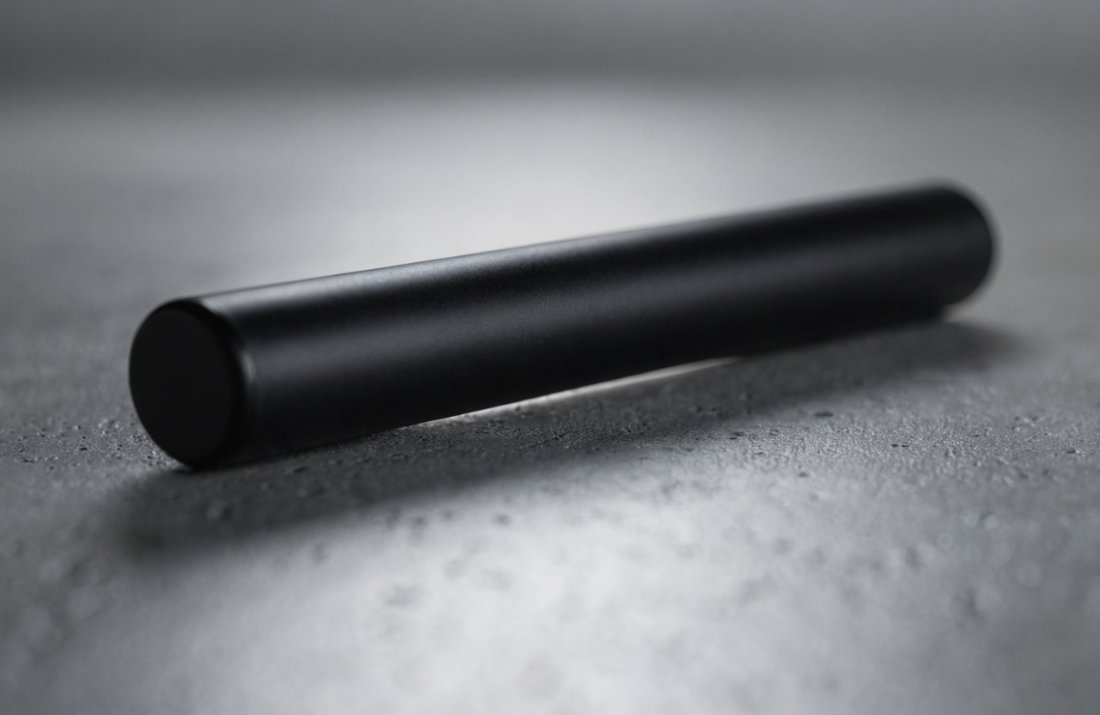 Close-up of a dual chamber vape pen on a concrete surface - Bud Cargo