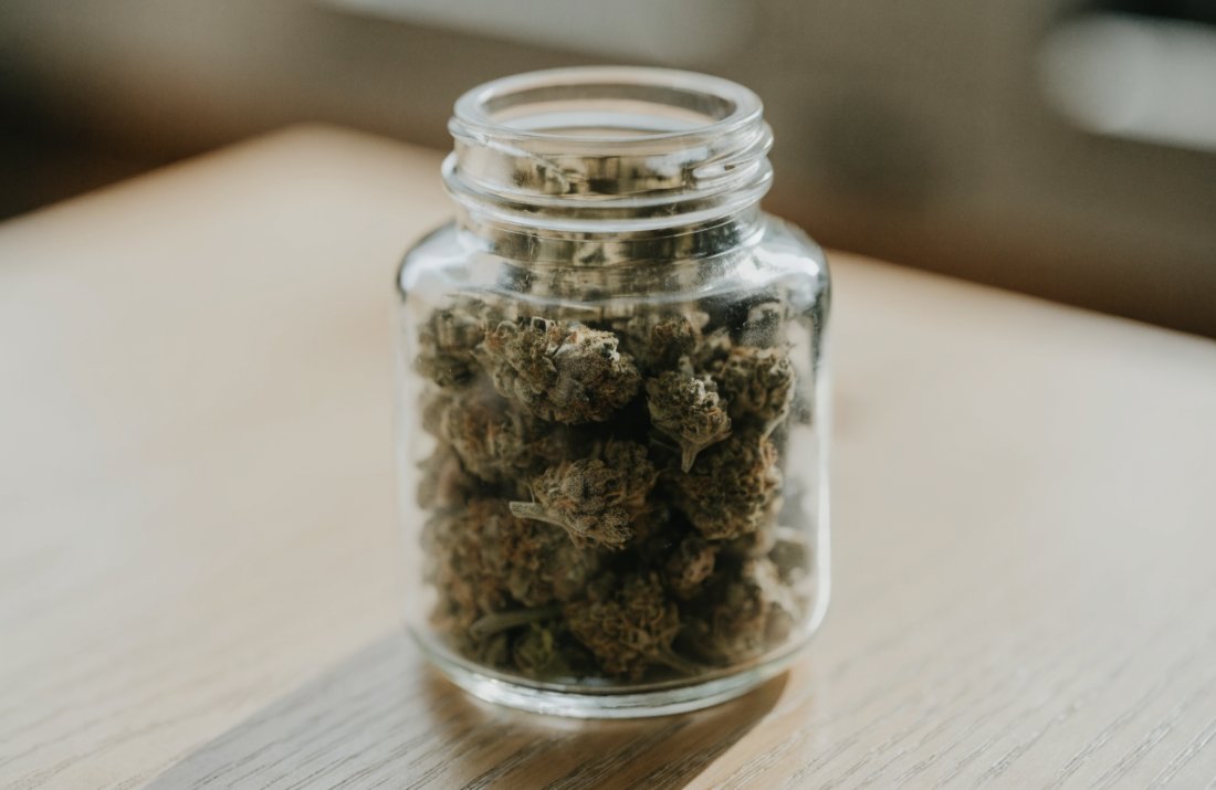 An ounce of cannabis flower stored in a glass jar - Bud Cargo