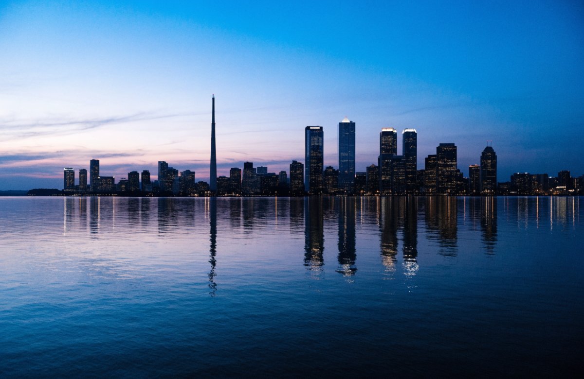 Toronto skyline across Lake Ontario at dusk
